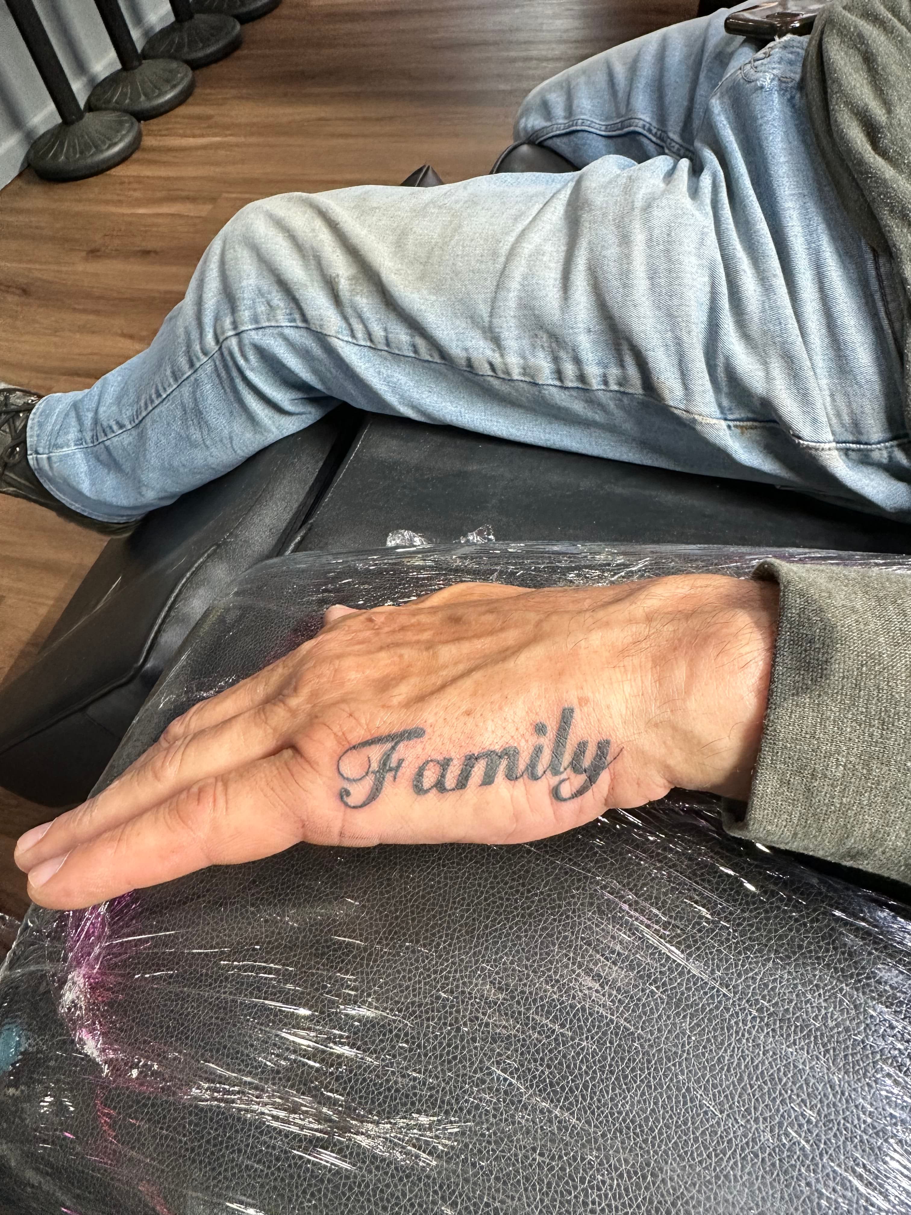 Hand tattoo spelling Family