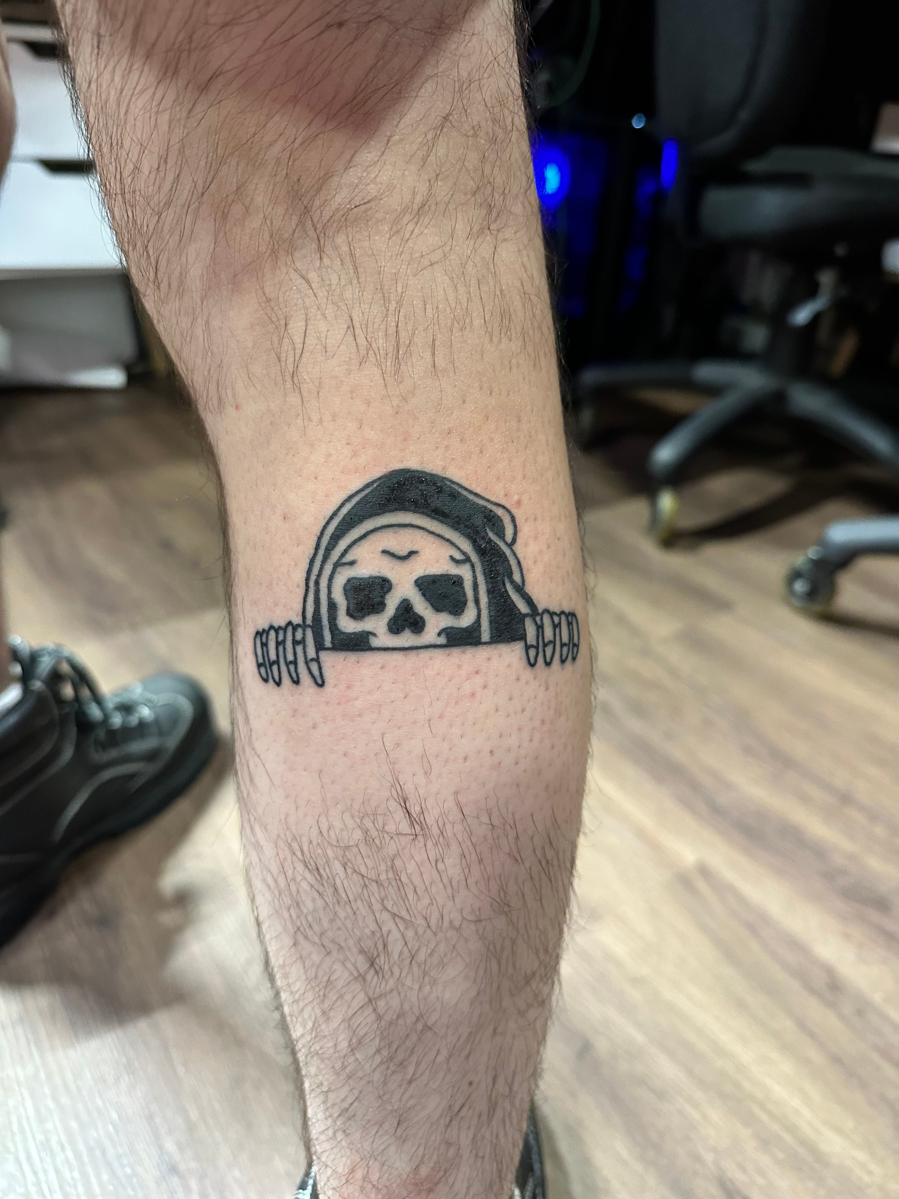 Grim reaper peaking over ledge tattoo